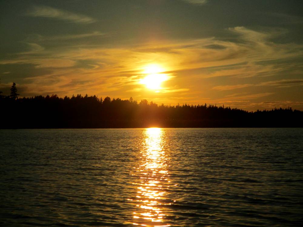Päikese laskumine Põdragu järve piirava püha metsamüüri taha